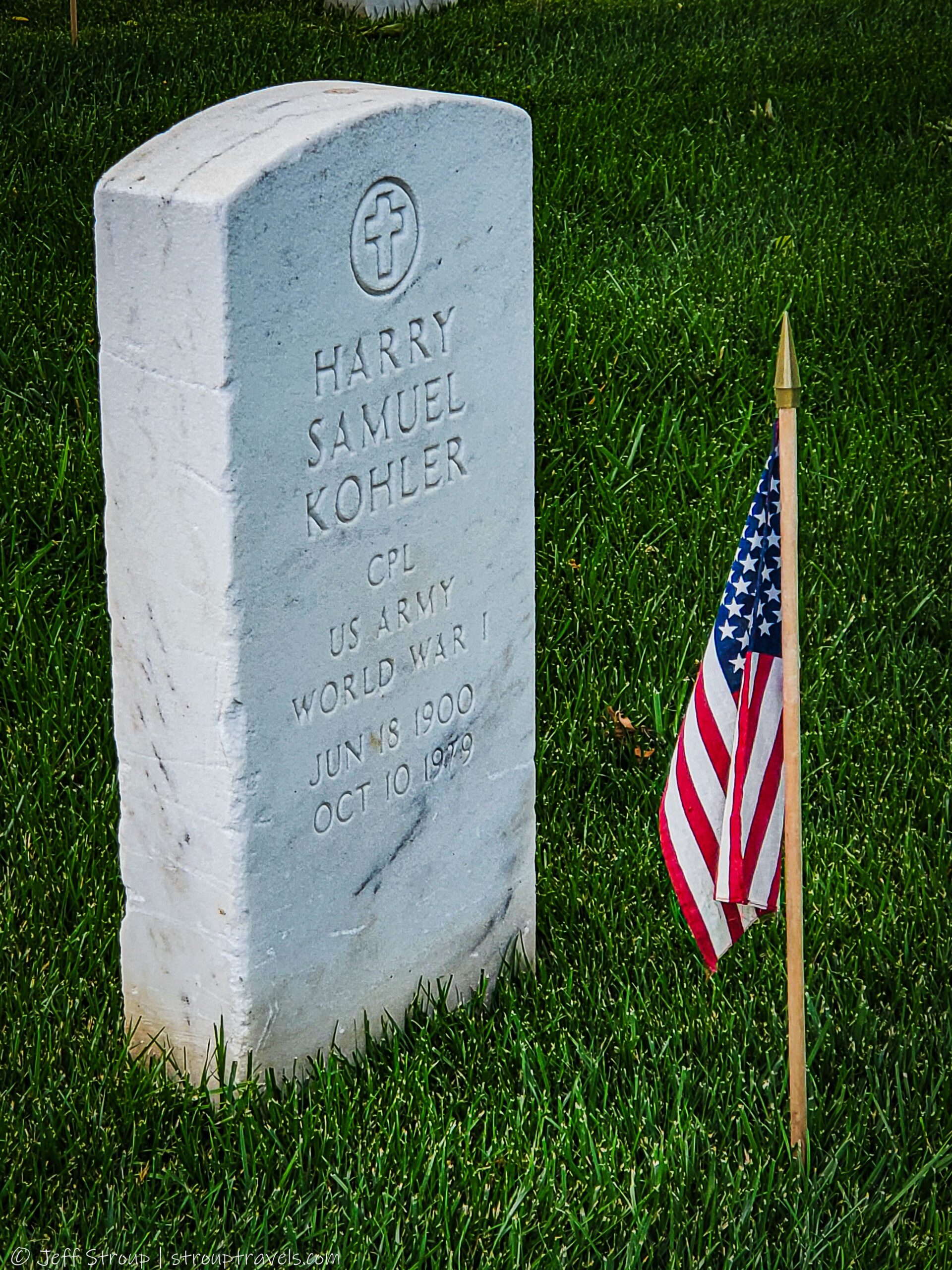 American flag beside the grave of Harry Samuel Kohler, CPL, U.S. Army, World War I at Arlington National Cemetery, symbolizing sacrifice and remembrance.